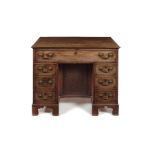 A George II mahogany and crossbanded kneehole dressing table/ desk