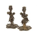 A pair of late 19th century patinated bronze candlesticks