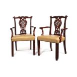 A pair of George III style carved mahogany open armchairs