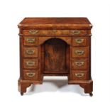 A Queen Anne walnut crossbanded and featherbanded kneehole desk