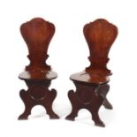 A pair of George III mahogany hall chairs