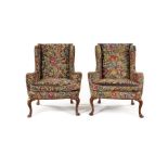 A pair of walnut and petit point wing armchairs, one chair George II the other of later date