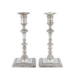 A pair of Edwardian silver reproductions of late George II/early George III cast candlesticks