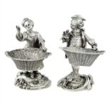 A pair of late Victorian cast silver novelty salts modelled as 18th century street vendors
