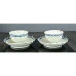 A pair of early English tea bowls and saucers, embossed with flowers, blue and white borders.