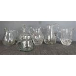 A group of glass jugs and a cut glass decanter.