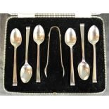 A set of six silver teaspoons and sugar tongs, in original box.