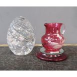 A gut glass egg form paperweight together with a Victorian cranberry glass jug.