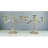 A pair of silver plated candleabra, each with three branches, in the Rococo style.