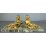 A pair of 19th century bronze cherubs, one holding a dove, the other a flaming torch, raised on