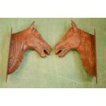 A pair of large iron horse heads wall plaques.