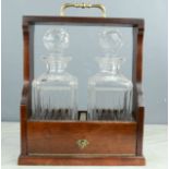 A tantalus, with two cut glass decanters, and key.