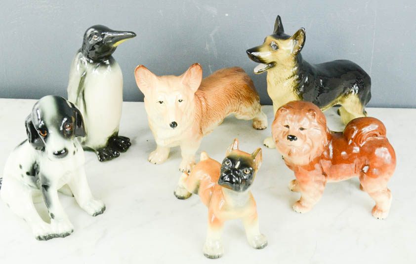 A group of ceramic animals; Penguin, Alsation, Spaniel, Corgi, Boxer, Pomeranian.