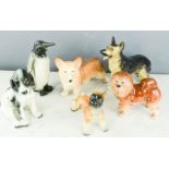 A group of ceramic animals; Penguin, Alsation, Spaniel, Corgi, Boxer, Pomeranian.