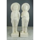 A pair of plasterwork figures; girl and boy wearing hats.