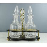 A Victorian tri-part decanter, ebonised and brass stand with three cut glass decanters.