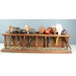 A pipe rack, with twelve pipes of different style including Meerschaum, buffalo head, horn handled