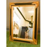 A reproduction wall mirror, giltwood with ebonised moulding.