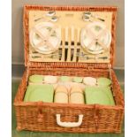 A retro wicker picnic basket, complete with bakelite contents.