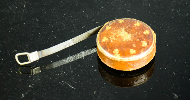 An original Girl Guides pocket tape measure, with tooled gilt Guiding trefoil motifs.