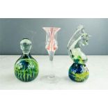 A Mdina glass seahorse paperweight, Caithness candlestick and a further paperweight.
