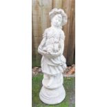 A reconstituted stone garden ornament in the form of a girl holding a basket of puppies.