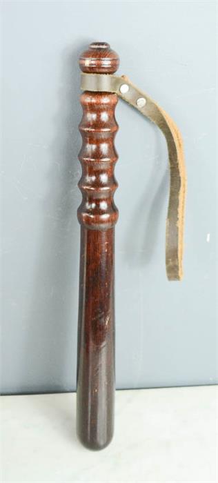 A wooden trucheon, circa 1950s, with leather strap.