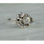 An Art Deco platinum and diamond ring, the old cut central diamond approx 1.8ct surrounded by an Art