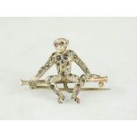 A silver, yellow metal and marcasite monkey brooch, 3cm long, 2cm high.