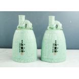 A pair of Chinese vases, pale green glaze, with calligraphy to the body.