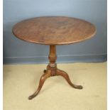 A Georgian oak tripod table with circular tilt top.