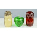 Three glass paperweights; two owls and one apple.