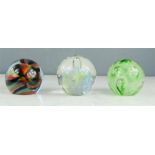 Three glass paperweights including Caithness Sorcerer M86074, Langham and another.