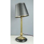 A Victorian brass and black ceramic lamp base with a black shade.
