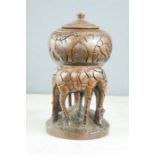 An African carved wooden jar, raised on carved giraffes.