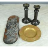A copper and pewter pin dish depicting cockerels, a pair of ebonised candle sticks, and a brass