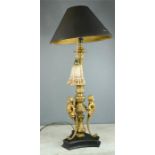 A composition table lamp modelled with cherubs, with black shade.