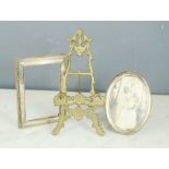 A silver oval and a silver rectangular photo frame together with a miniature brass easel/stand.