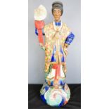 A large ceramic polychrome figure of a man holding the sun, possibly Chinese.