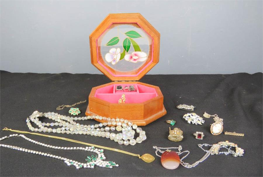 A wooden jewellery box containing a group of costume jewellery including silver rings and a cameo