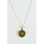 A 9ct gold locket and chain, the locket of circular form, engraved with decoration, 2.6g.