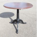 A cast iron and mahogany table, with telescopic base.