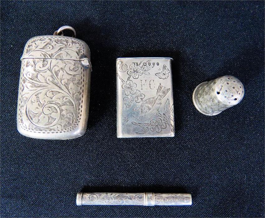 A group of two vesta cases, thimble and toothpick.