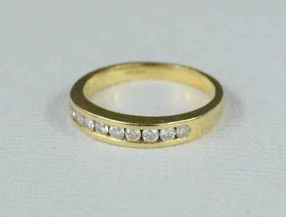 An 18ct gold ring, set with a band of diamonds, 2.8g..