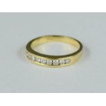 An 18ct gold ring, set with a band of diamonds, 2.8g..