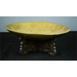 A Chinese brass dish engraved with dragons on a wooden stand 26cm high.