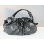 A black leather Prada handbag, with outer bag slip.