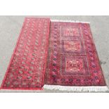 A Persian rug with red ground, and a red runner.