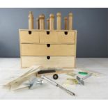 A set of small drawers containing jewellery making equipment to include wooden burrs,, screws and