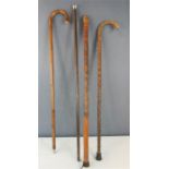 A silver topped cane, and three further walking sticks.